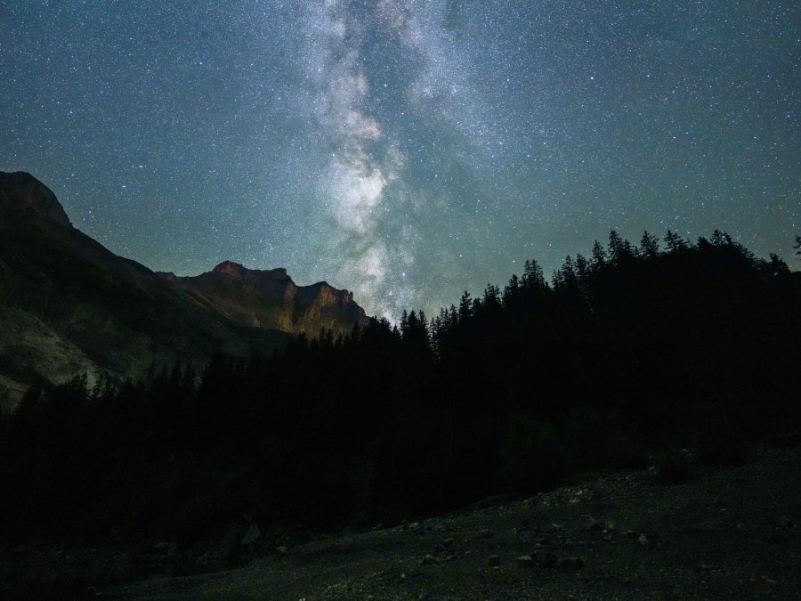 The Milky Way rising over a jagged mountain ridge silhouette at night