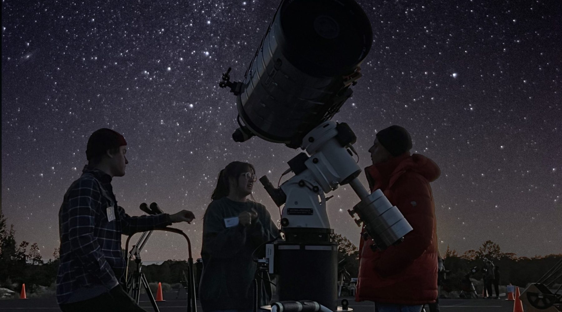 Telescope silhouetted against the Milky Way at a night star party