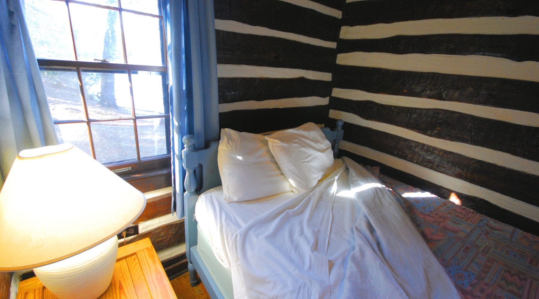 Rustic wood cabin bedroom interior with a window