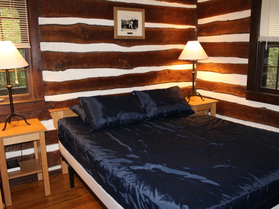 Cozy log cabin bedroom interior with a queen bed